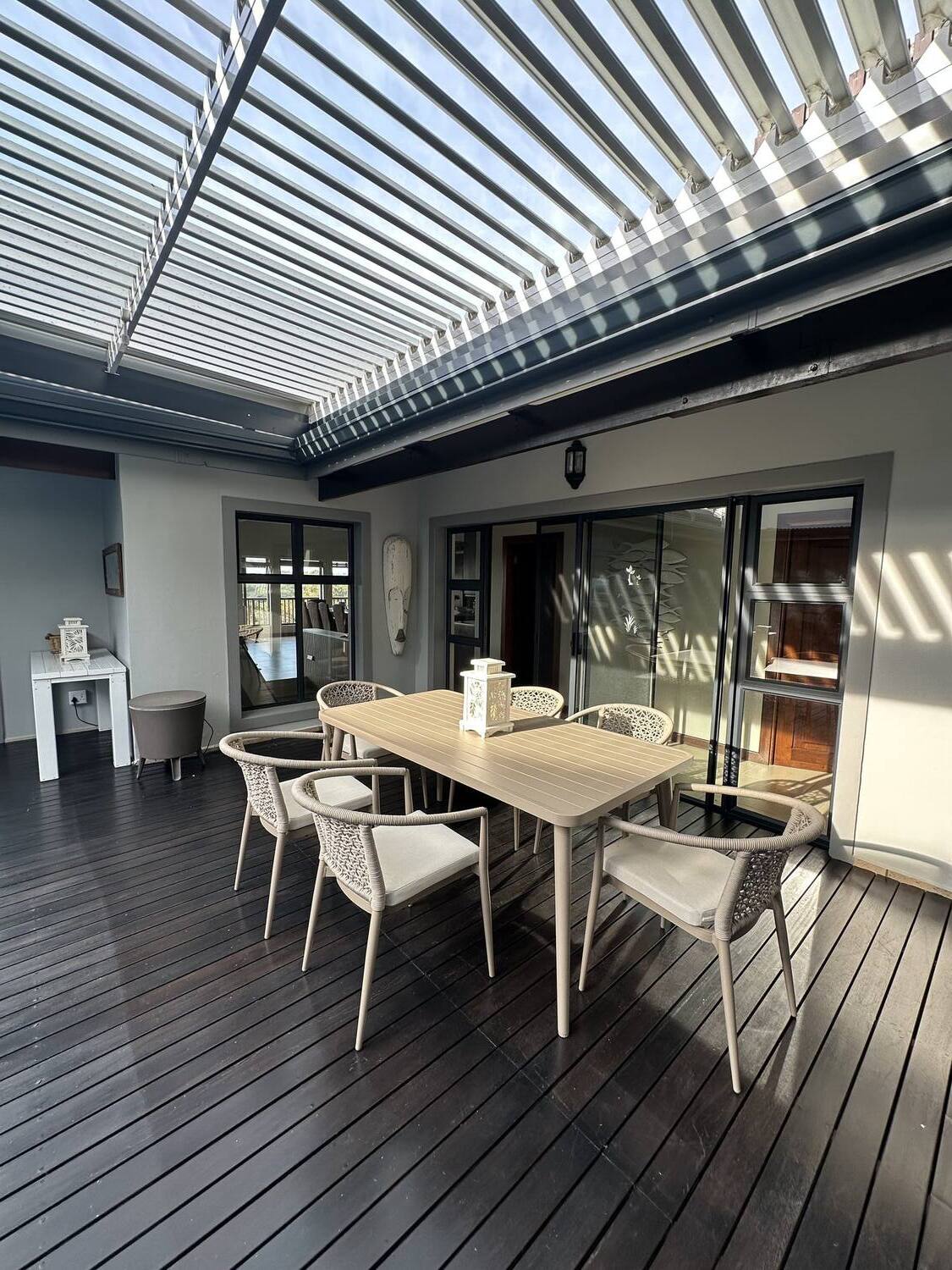 Outdoor deck dining area under louvered pergola