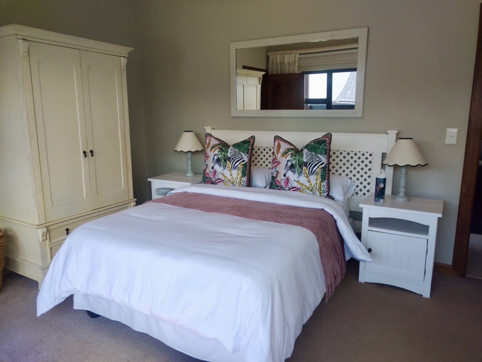 Third en-suite bedroom with tropical styling and twin bedside lamps